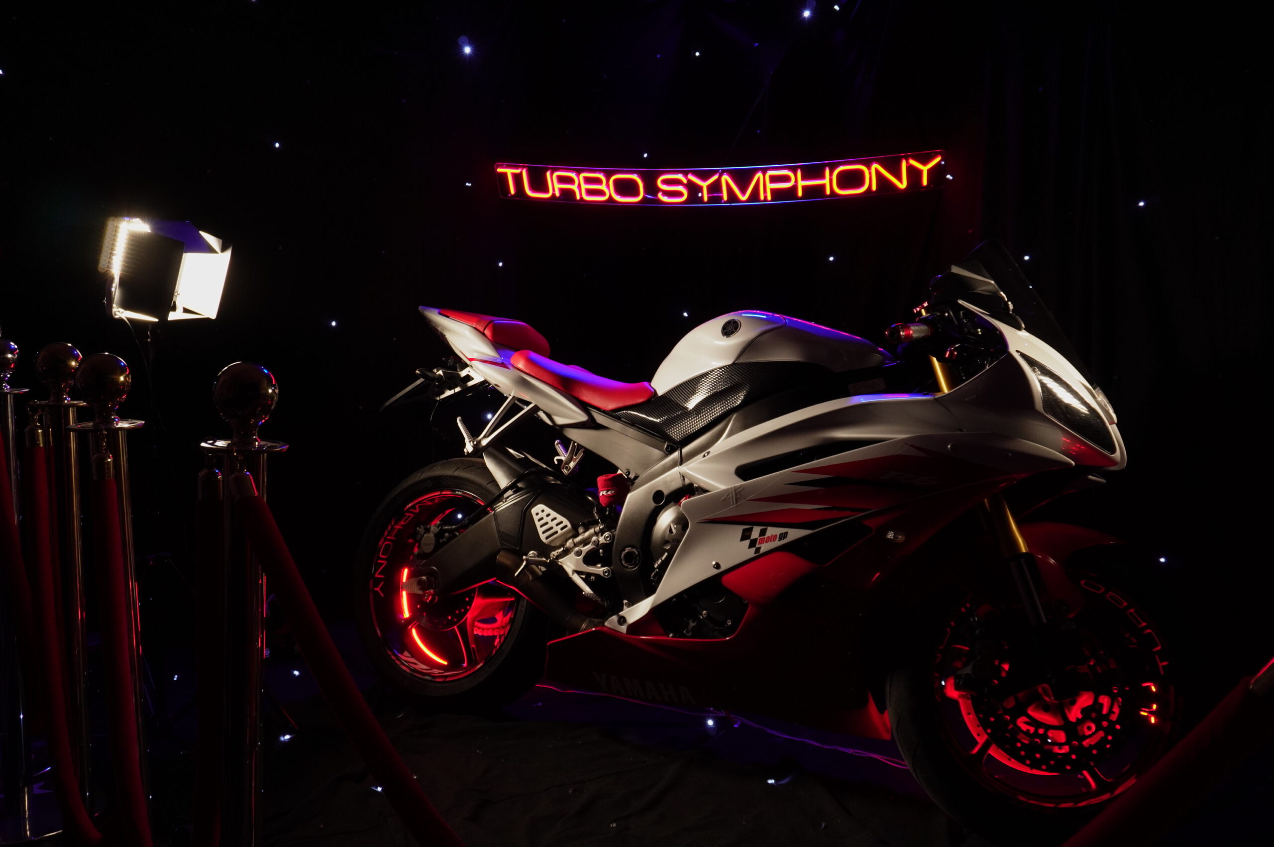 La Yamaha R6 di TurboSymphony™ in scena: insegna al neon rossa e red carpet